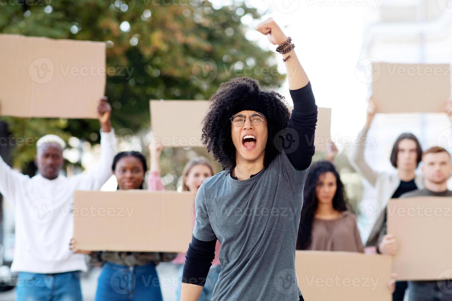 Guy leading international group of students strikers with blank placards protesting on the street, fighting against corruption in school and free education. Student strike, campus strike concept photo