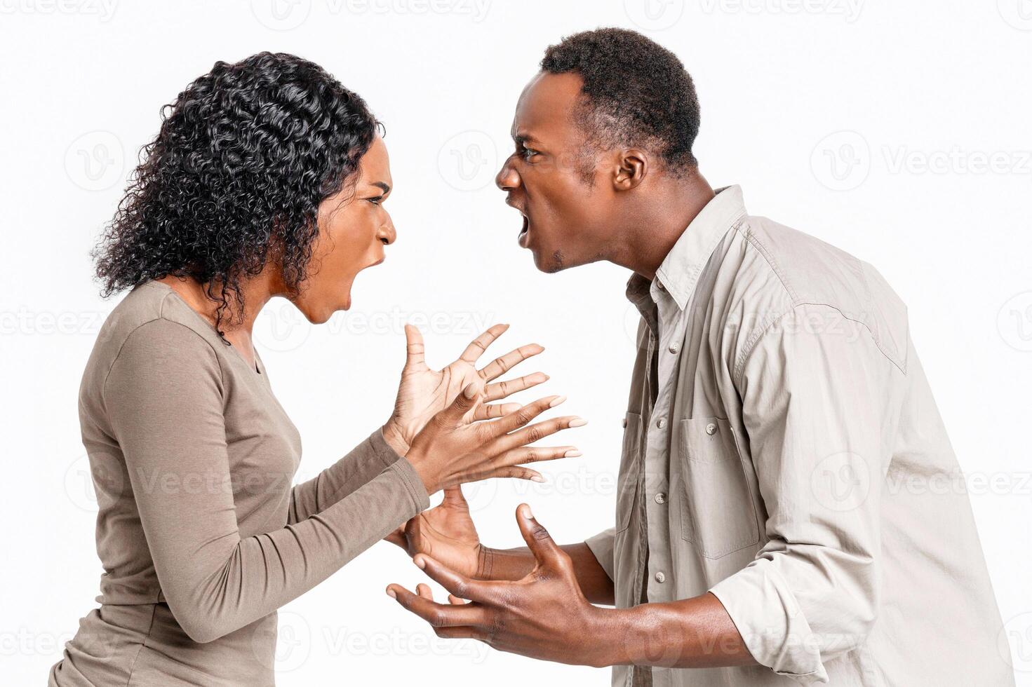 Fight during isolation. Angry black man and woman shouting at each other over grey studio background. Closeup of african american couple fighting, looking at each other and yelling, profile view photo