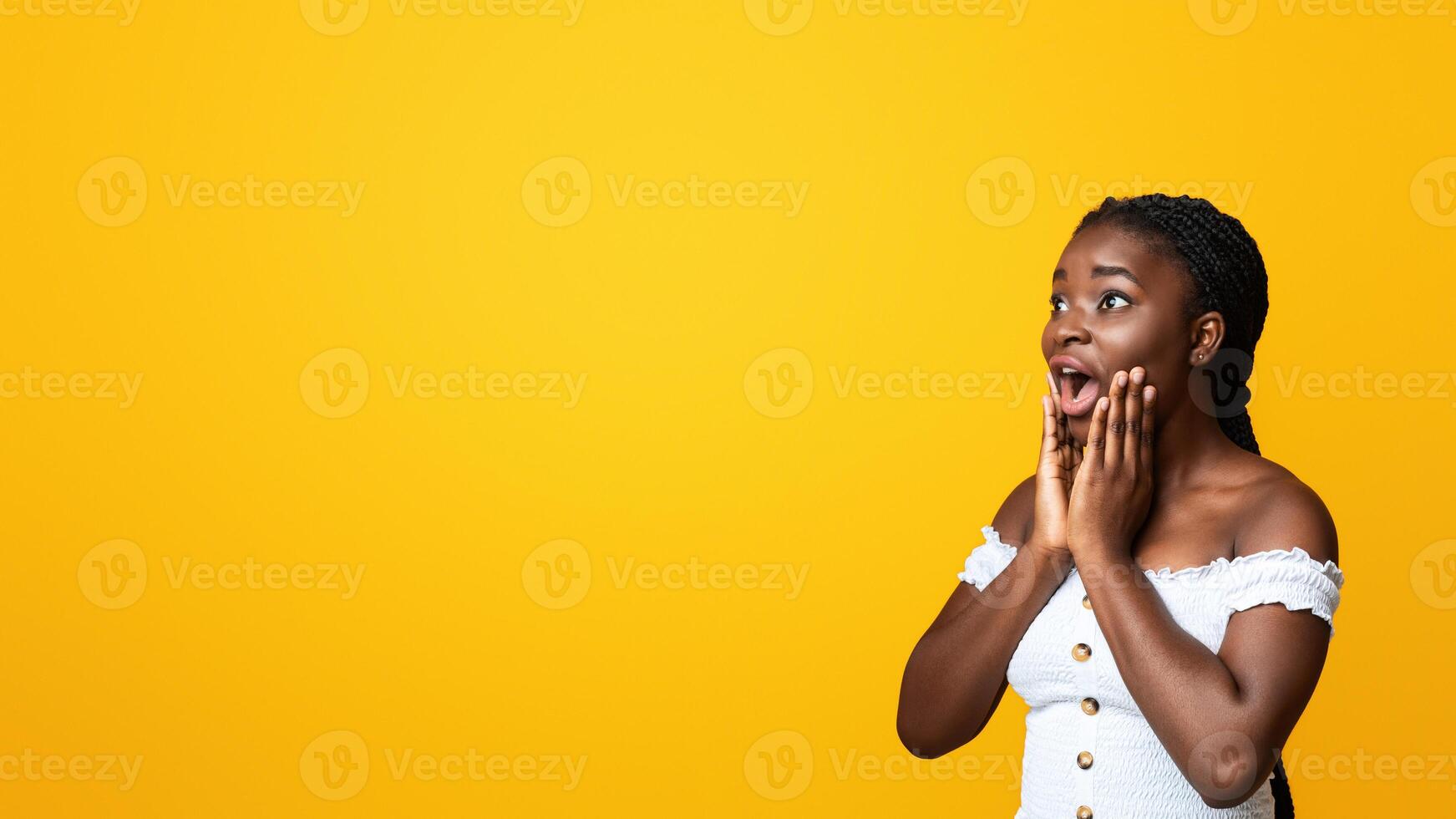 Shocking Offer. Emotional Black Woman Looking At Copy Space With Amazement And Touching Face With Excitement, Dazed African American Lady Standing Isolated On Yellow Background, Panorama photo