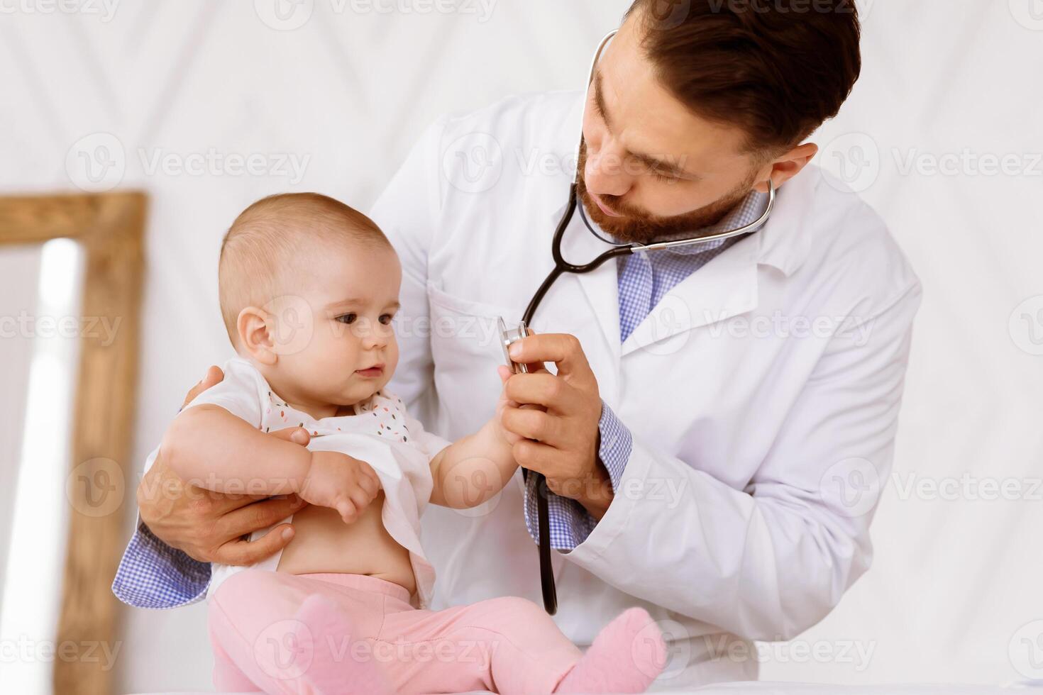 Doctor Examining Little Baby On Medical Checkup Listening To Child's Heartbeat With Stethoscope Checking Heart And Lungs In Clinic. Toddler Patient Having Appointment At Pediatrician's Office photo