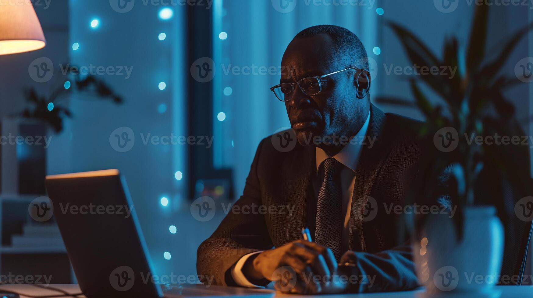 This Individual talks on a call from a cozy, softly illuminated workspace at night. photo