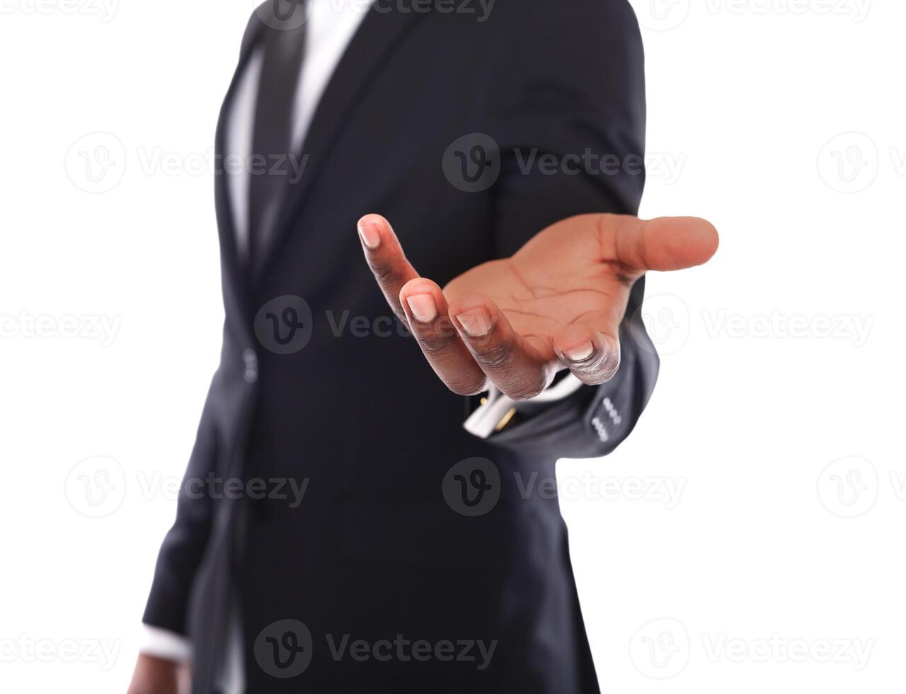 Unrecognizable businessman welcoming you isolated. Cropped image of african american man in suit opening palm in inviting gesture photo