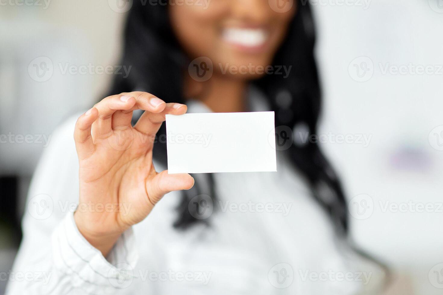 Black female entrepreneur holding empty business card at company office, mockup for design. African American CEO manager demonstrating blank advertising card, selective focus photo