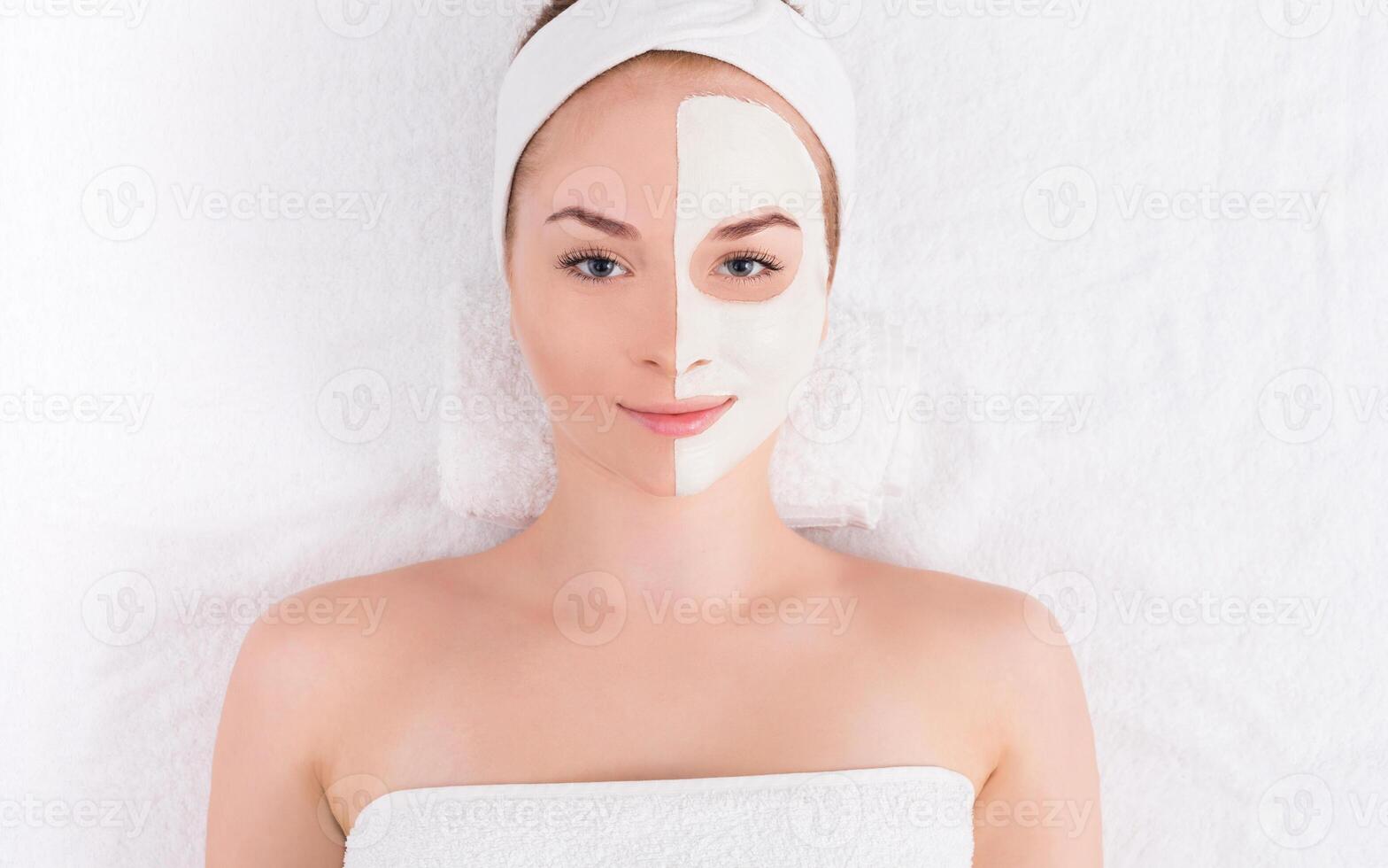 Face mask, spa beauty treatment. Woman applying facial clay mask at spa salon, skincare, top view, overhead photo