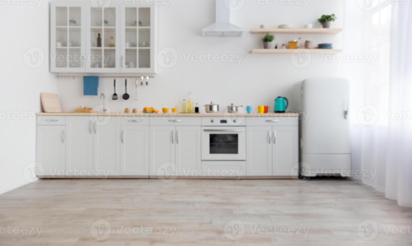 Bright accessories and modern style of kitchen interior. White furniture with utensils, colored cups and kettle, shelves with dishes and plants in a pots, refrigerator in dining room, empty space photo