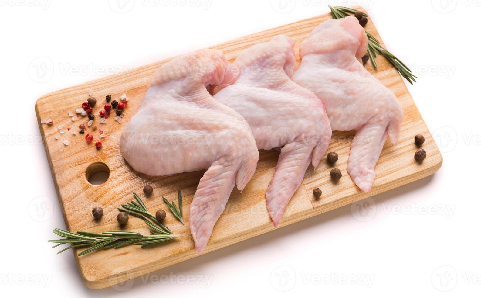 Raw chicken wings with spices for cooking on a wooden cutting board photo