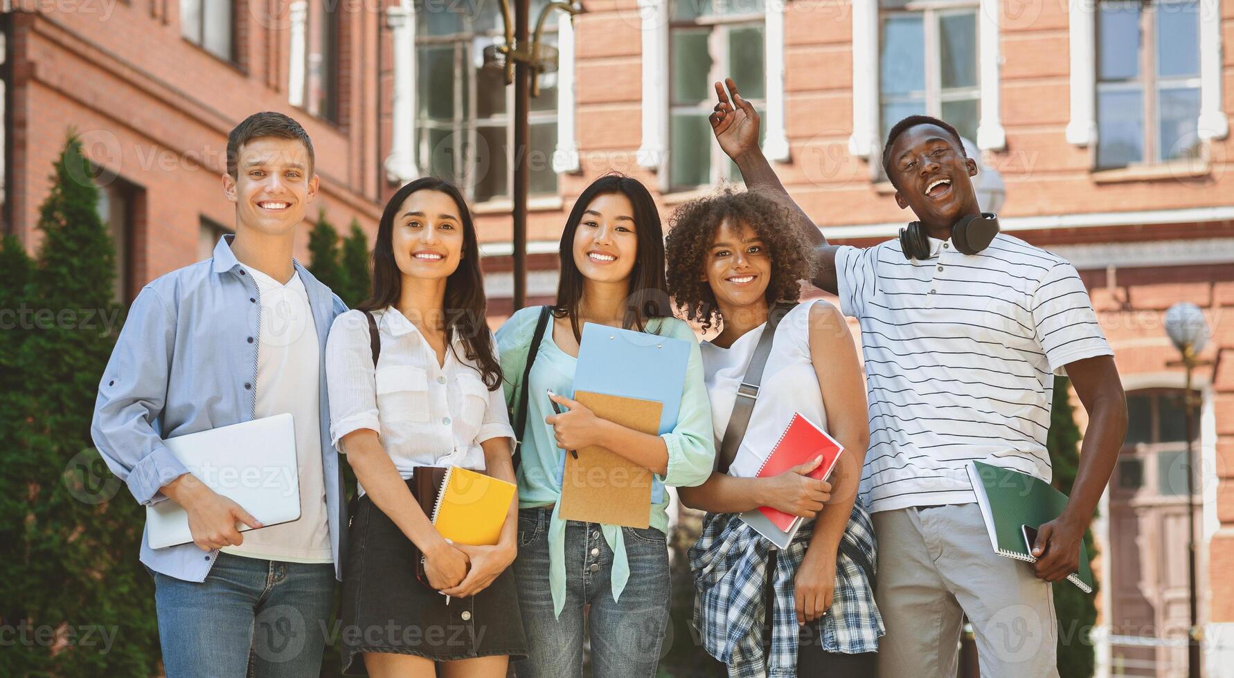 Freshmen Orientation Concept. Group Of First Year Students With Workbooks Posing Together Outdoors, Panorama With Free Space photo