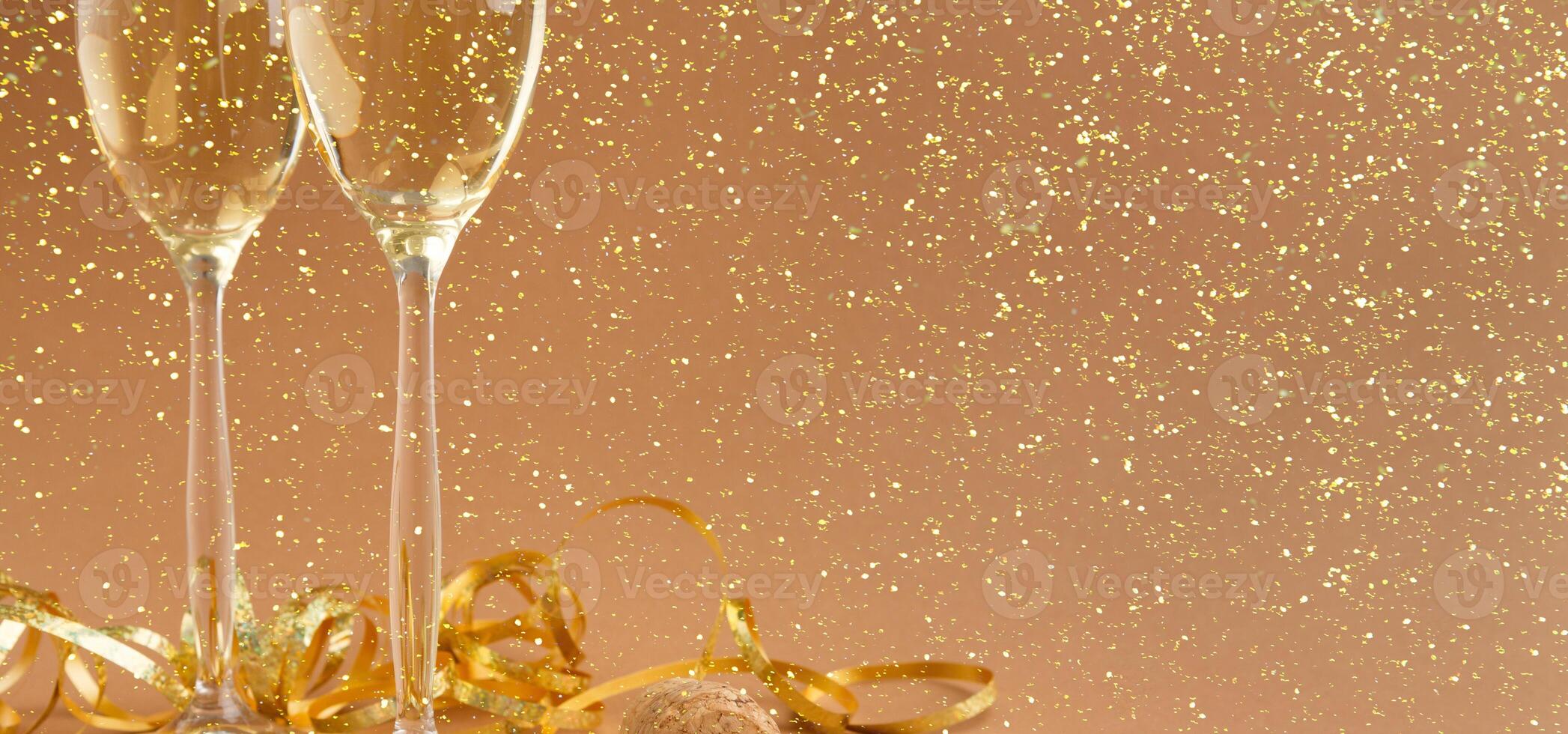 Champagne flutes and bottle cork with 2019 numbers at golden holiday background with glitters and tinsel. Celebrating christmas, new year or birthday. Mockup for xmas postcard, crop photo