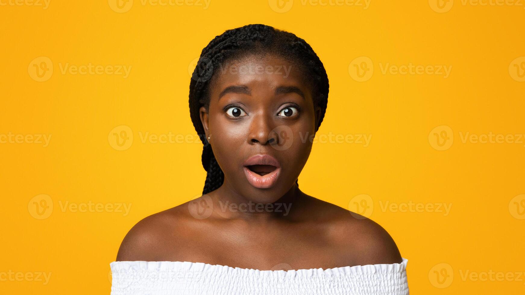 No way. Closeup portrait of shocked young african american woman opened mouth in amazement, emotionally reacting to news, standing over yellow studio background and looking at camera, free space. photo