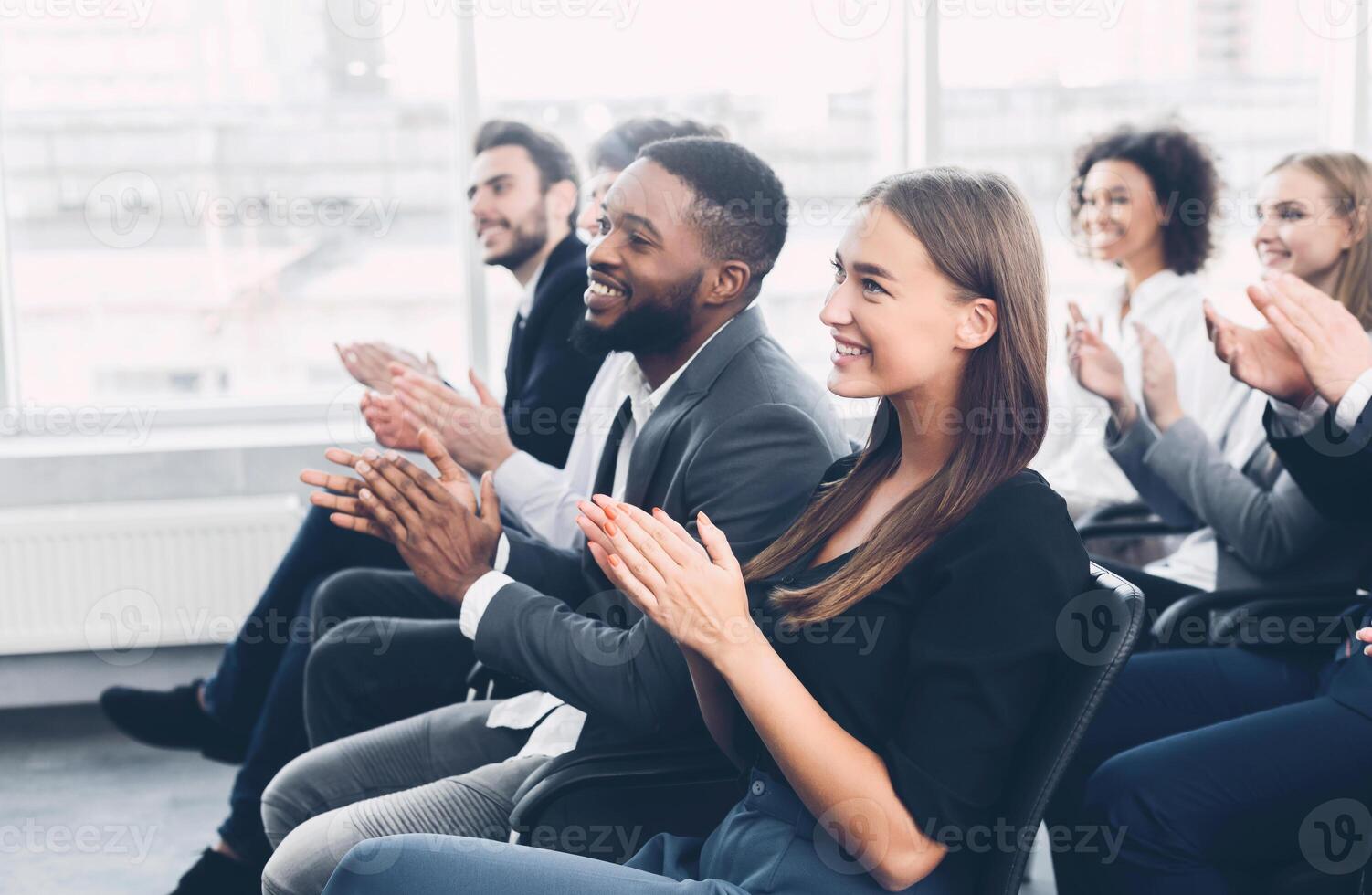 Group of business people applauding speaker after presentation in conference room photo
