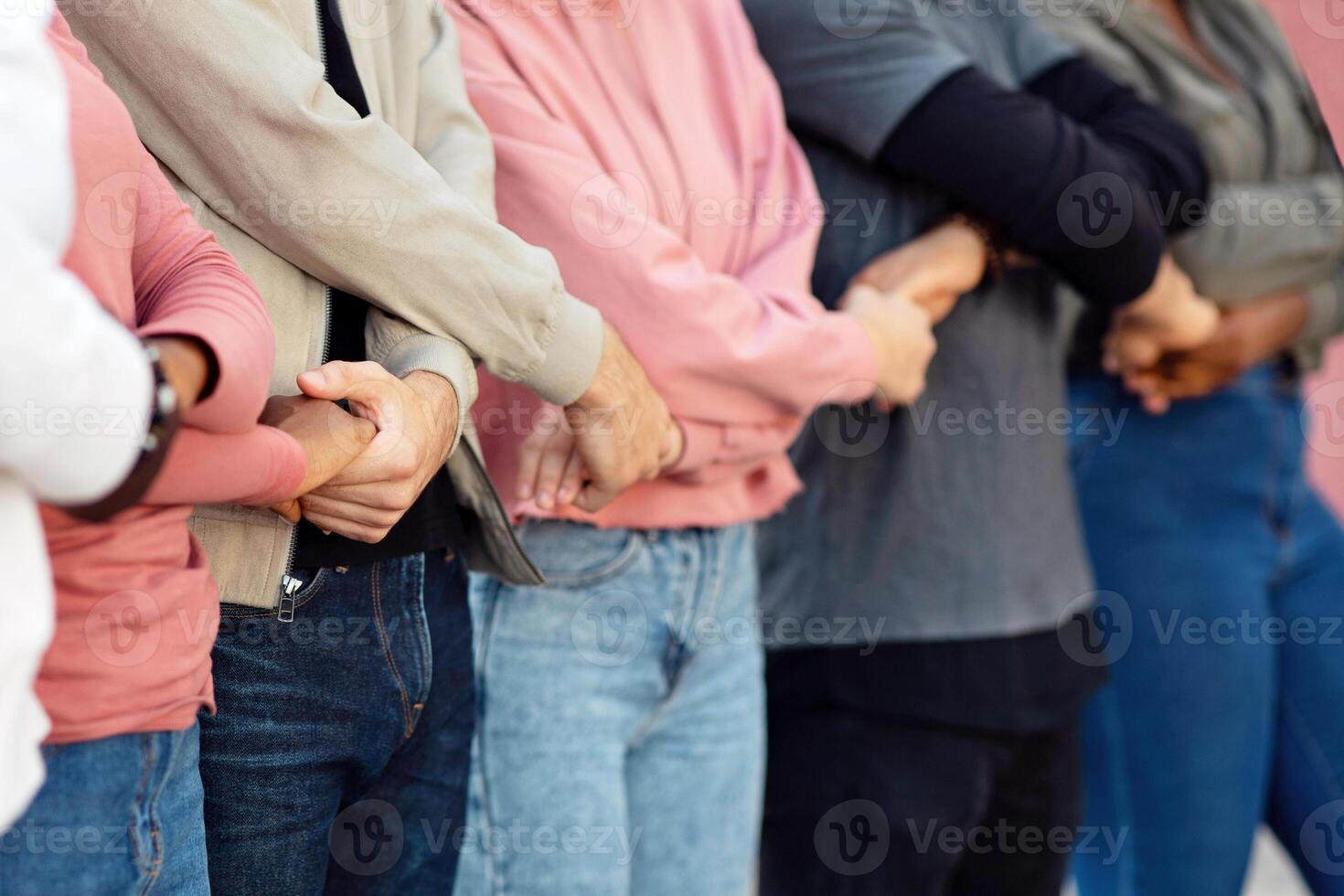 International group of unrecognizable protestors standing together holding hands in protest picket on the street. Male and female activists protesting silently, expressing unity and strength, cropped photo