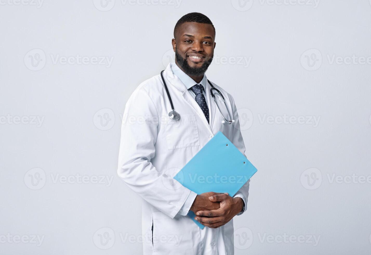 Young happy black medical doctor holding medical chart over white studio background, copy space photo
