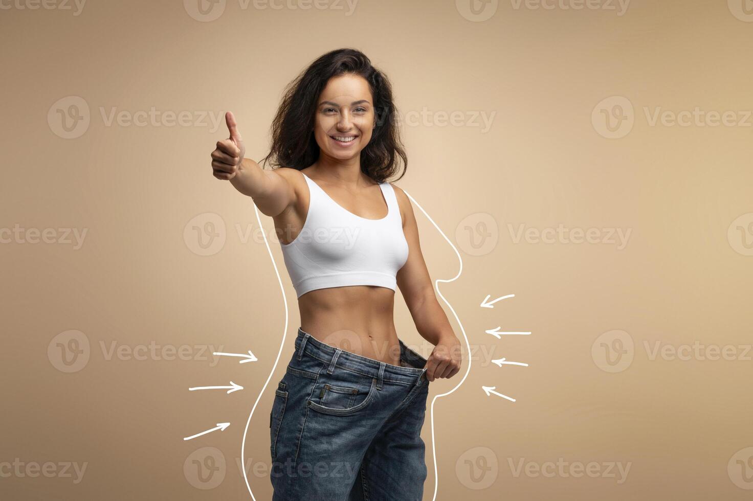 Happy attractive slender young middle eastern woman wearing huge jeans, showing thumb up, results of diet, white body shape lines around happy slim lady, collage for slimming concept, copy space photo