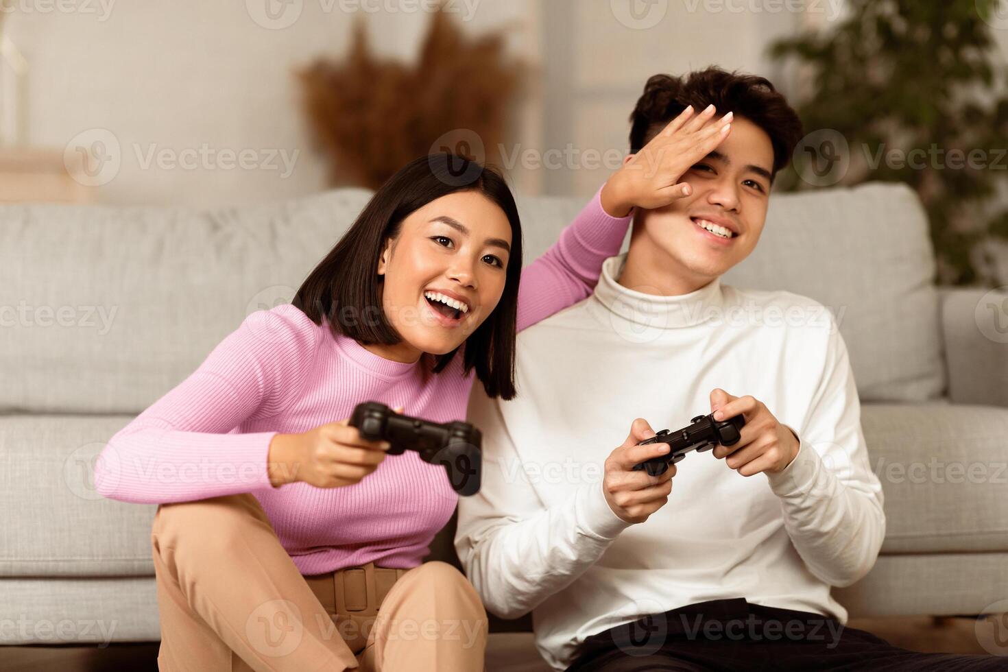 Happy Asian Couple Playing Computer Game Sitting On Couch At Home. Japanese Boyfriend And Girlfriend Play Videogames On Weekend. Family Fun, Gaming Concept photo