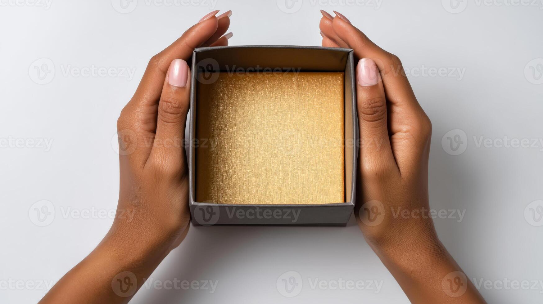 A pair of hands grips an open box, showcasing its smooth gold interior. This moment captures the excitement of unboxing a new delivery, highlighting the anticipation and surprise. photo