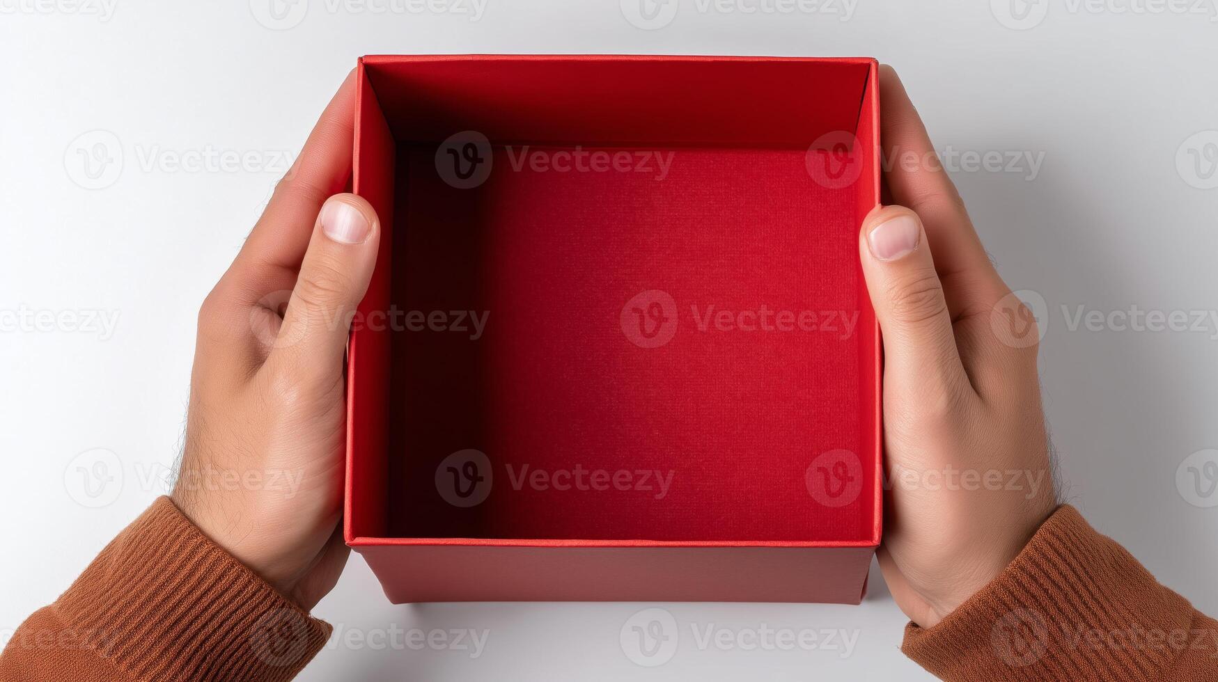 Two hands grasp a bright red box that is empty and open, ideal for wrapping a gift or shipping items. The box is shown from above, emphasizing its vibrant color and interior. photo