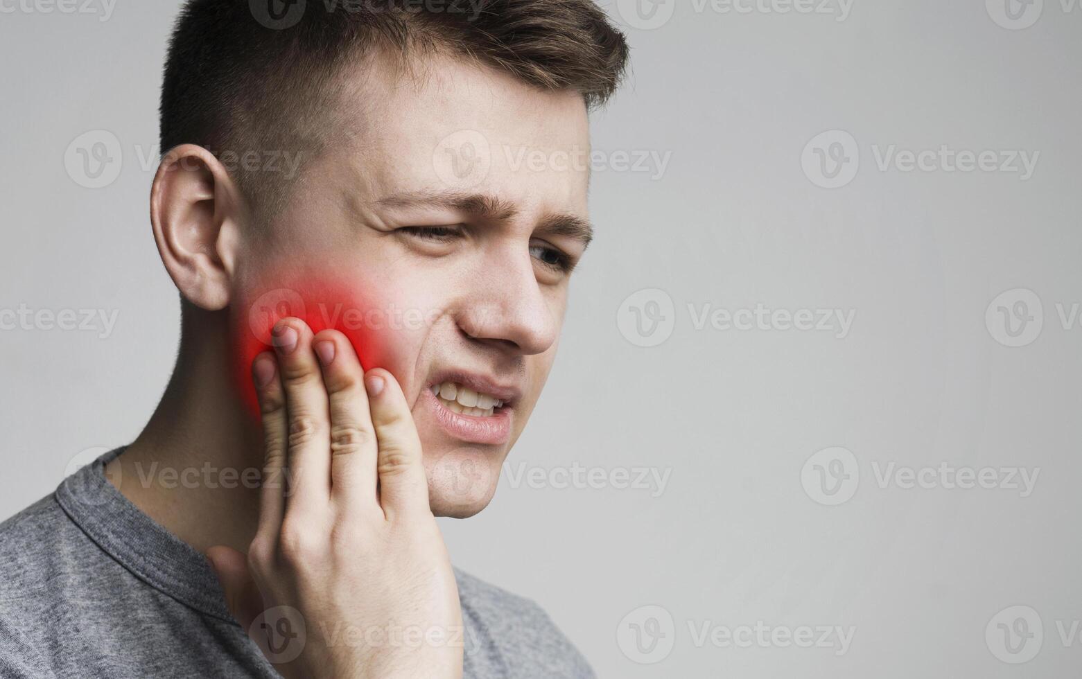 Toothache. Frustrated young man touching his cheek and frowning face, panorama photo