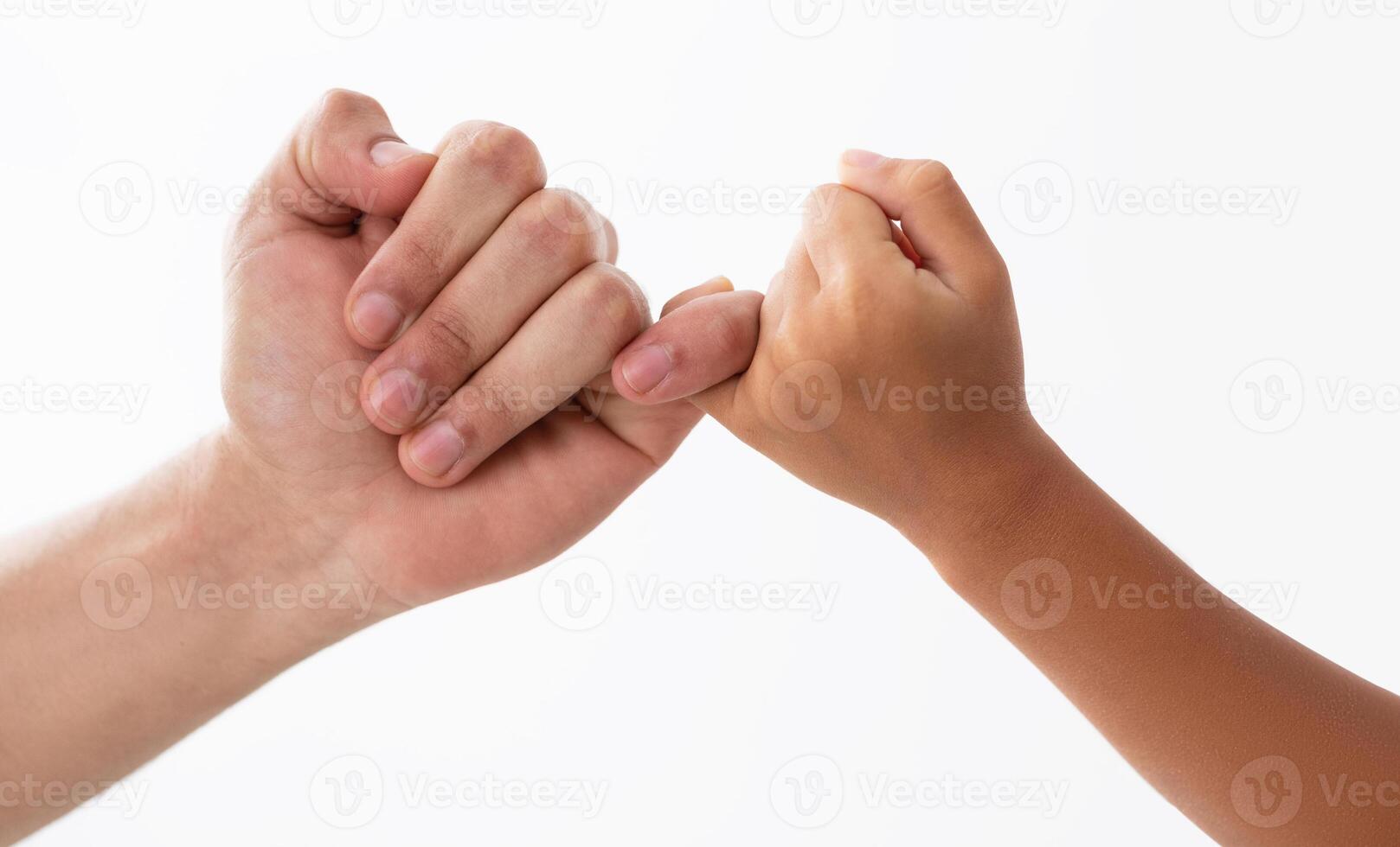 Friendship Concept. Cropped close up view of father and daughter making promise with hands holding little fingers, isolated on white studio background. Pinky swear photo