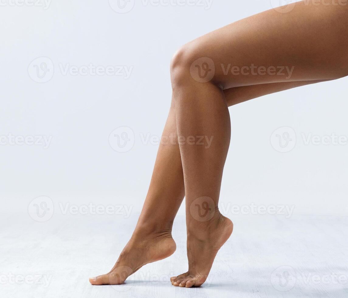 Sexy legs of african woman over grey background, cropped, laser hair removal procedures, copy space photo