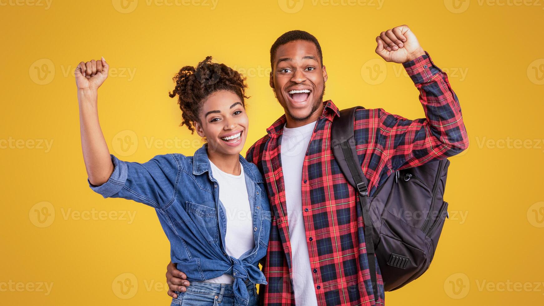 Joy Of Travel. Happy Black Tourists Couple With Backpacks Gesturing Yes Going On Vacation Posing Standing On Yellow Studio Background. Local Tourism, Traveling And Holiday Trip Concept photo