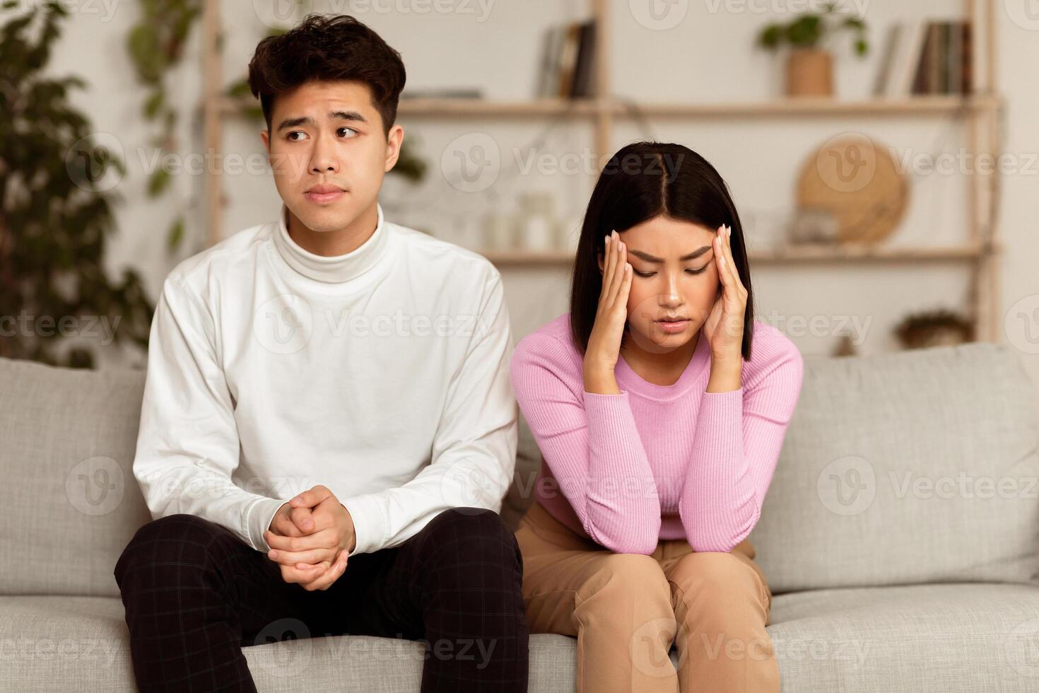 Chinese Spouses Not Talking Sitting Offended Having Marital Problems At Home. Unhappy Family Couple After Conflict Quarrel. End Of Romantic Relationship, Divorce And Breakup Concept photo