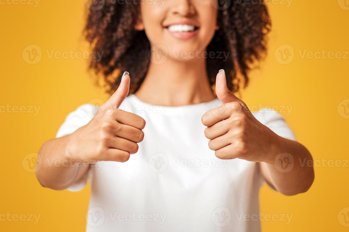Great offer, huge sale and approval gesture. Smiling millennial african american female with curly hair in white t-shirt, showing thumbs up isolated on yellow background, studio shot, empty space photo