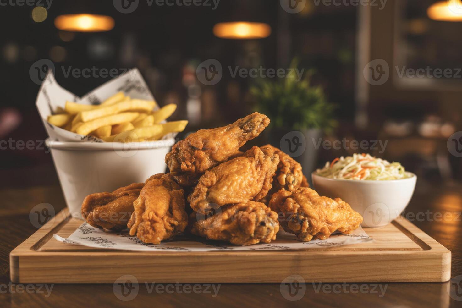 Crispy Fried Chicken Wings Served with French Fries and Coleslaw on Wooden Platter photo