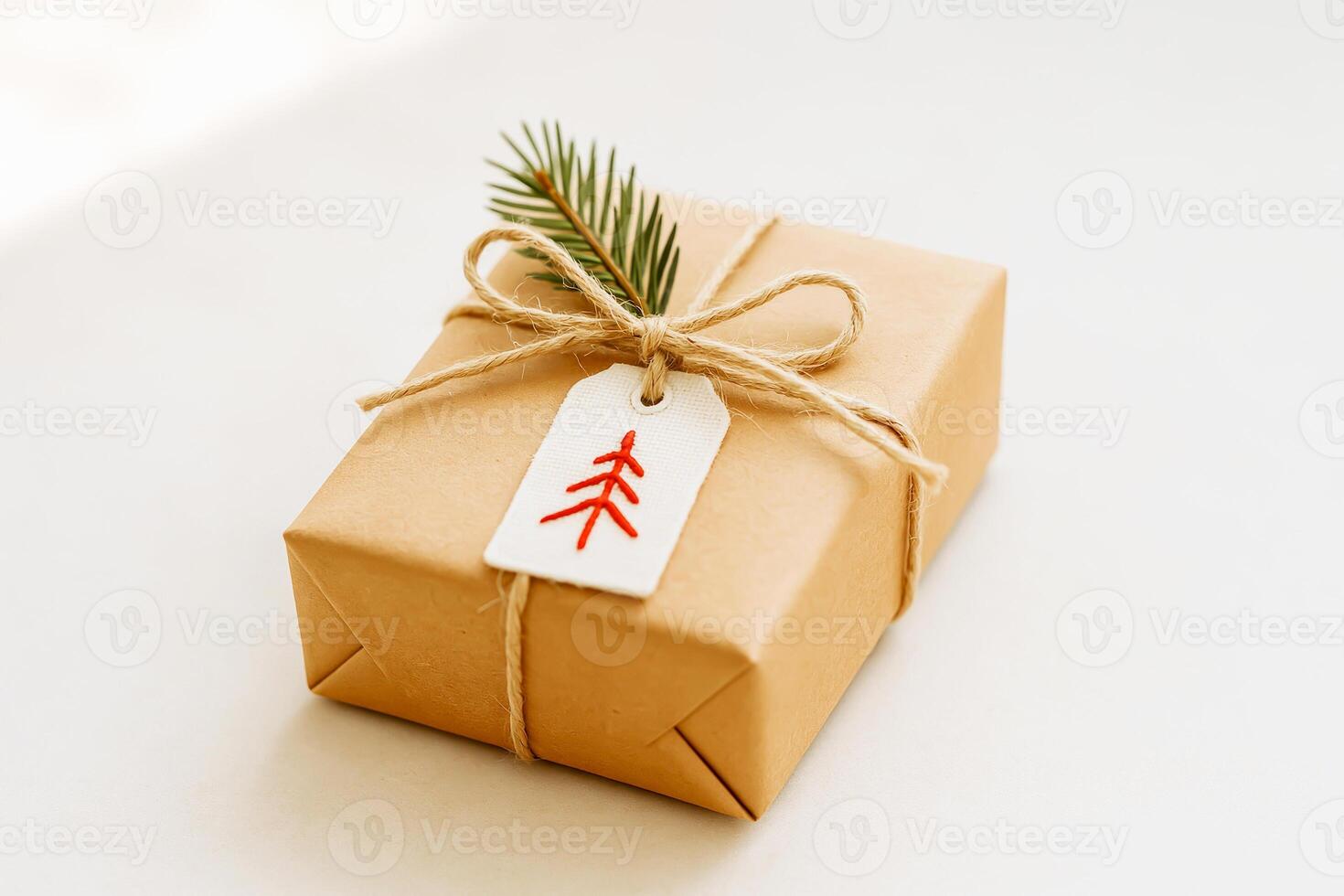 Christmas Gift Wrapped In Kraft Paper With Pine Twig And Handmade Embroidery Tag photo