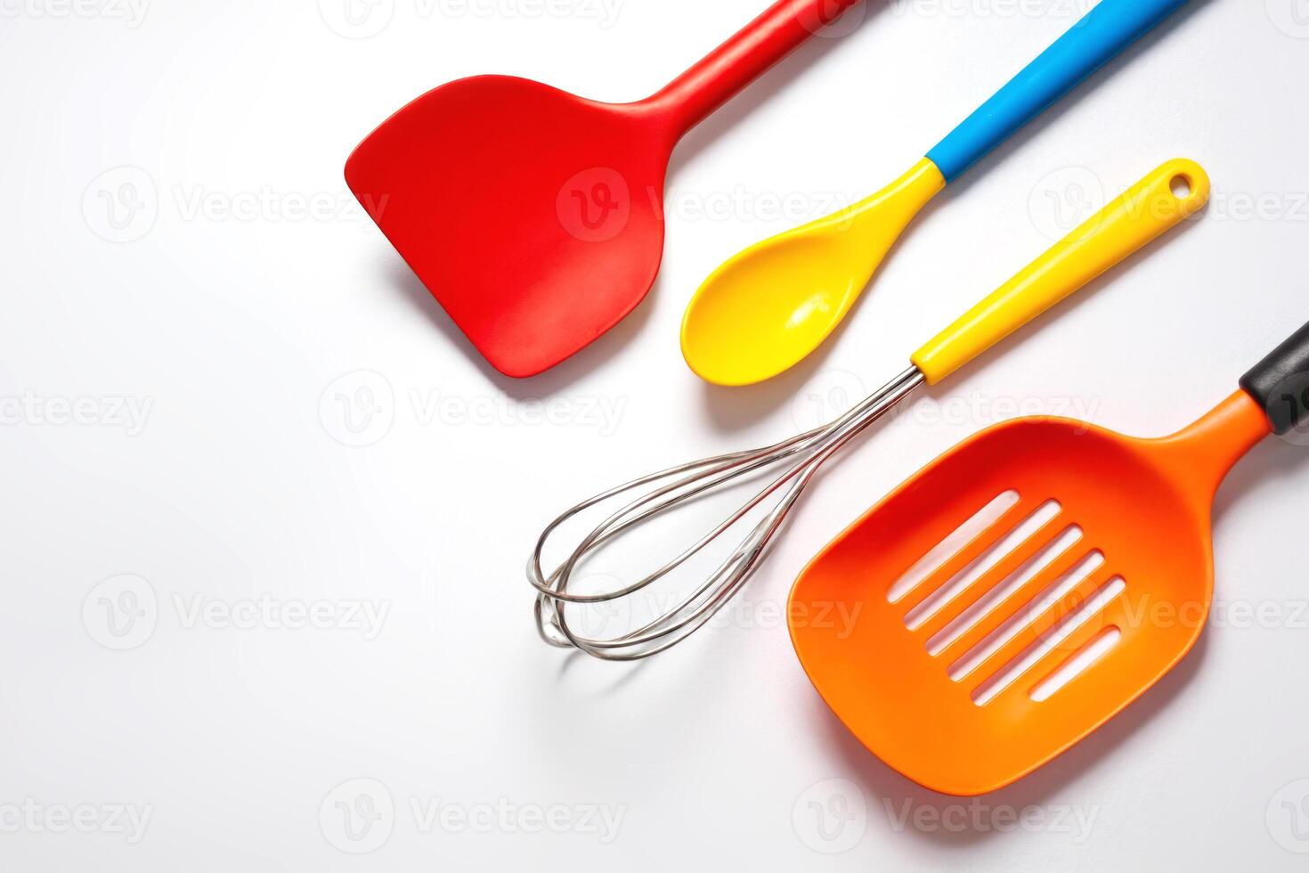 Colorful silicone kitchen utensils arranged on white background. Concept of modern cooking tools, vibrant kitchen accessories, home baking, culinary creativity, and functional design photo