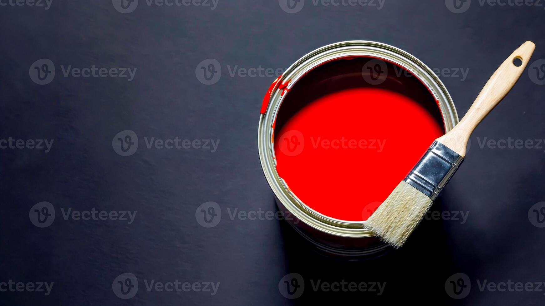 Open can of vibrant red paint with brush resting on edge against dark background, creating bold contrast. Perfect for painting services, interior design, color trends, DIY and creative branding photo