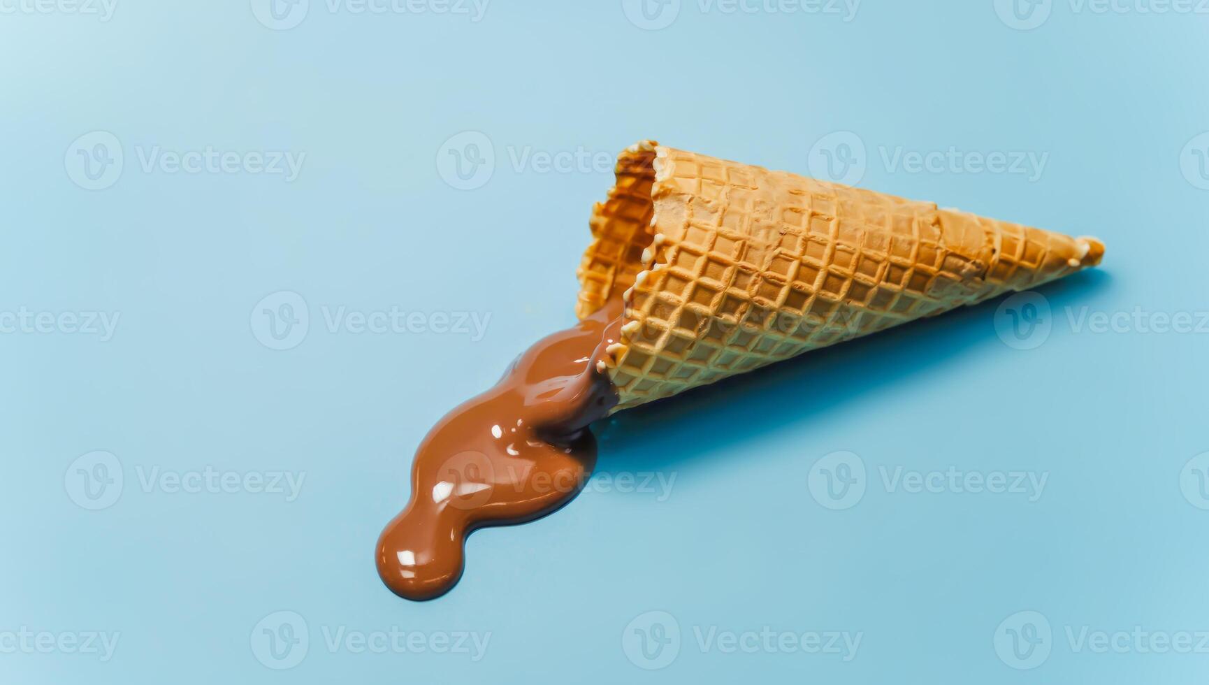Empty waffle ice cream cone with melted chocolate ice cream photo