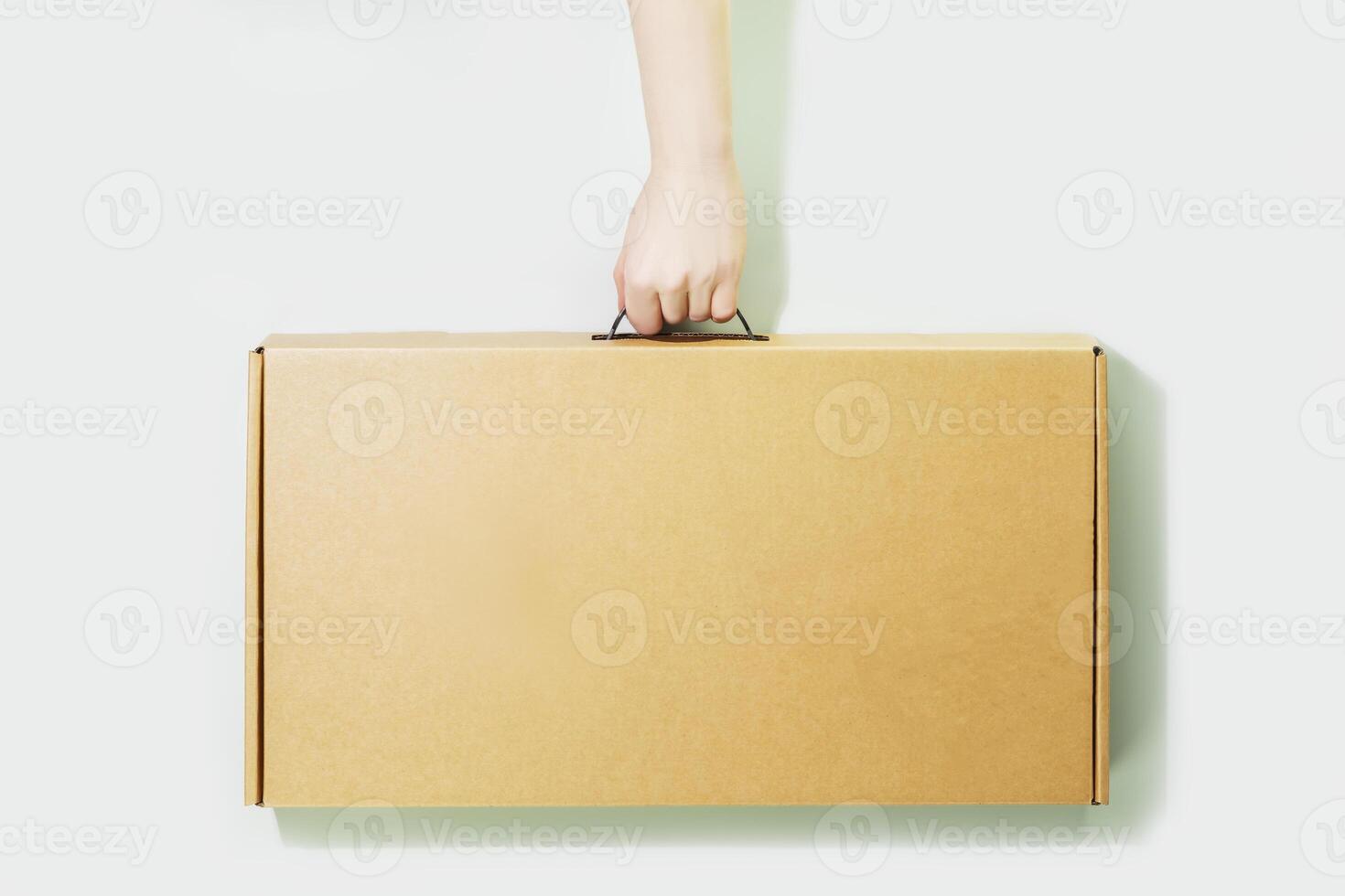 Eco friendly shopping and delivery service concept. Sustainable life style with cardboard box in delivery man hand on light blue background. Plastic free and eco packaging. Mockup, copy space photo