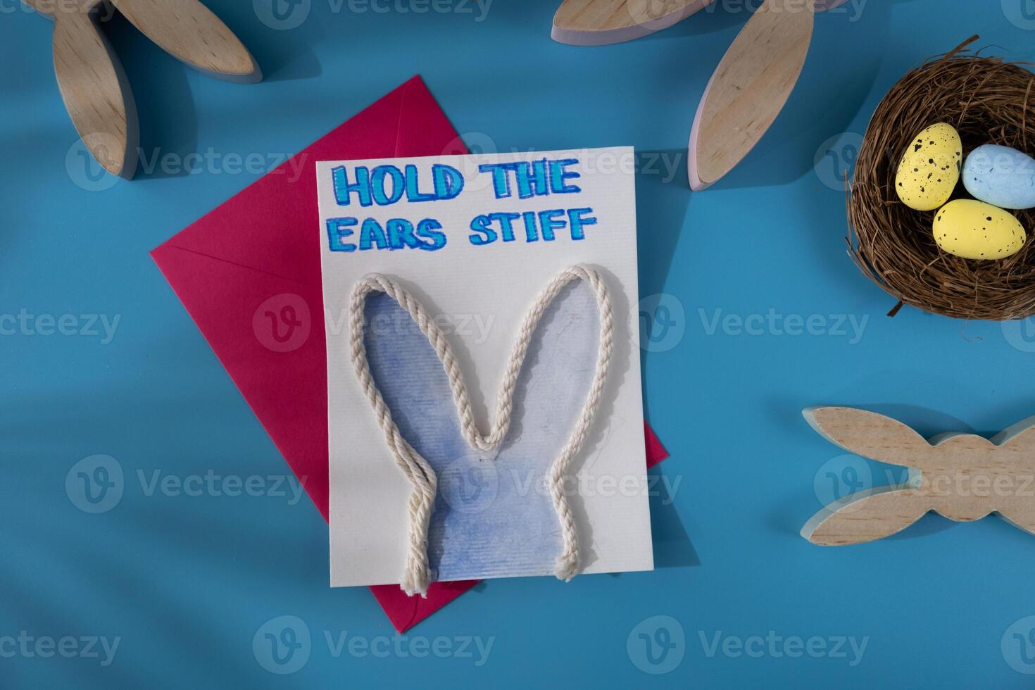 Handmade greeting card in colorful envelope letter with humor message HOLD THE EARS STIFF written in beautiful handwriting. Gesture shows excitement and joy for the upcoming event. Springtime holiday gift present zero cost ideas. Creative art preparation photo