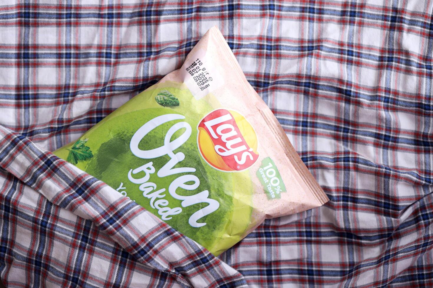 KYIV, UKRAINE - APRIL 19, 2025 Lays Oven Baked Yoghurt with herba flavoured potato chips in pack with Lays official logo photo