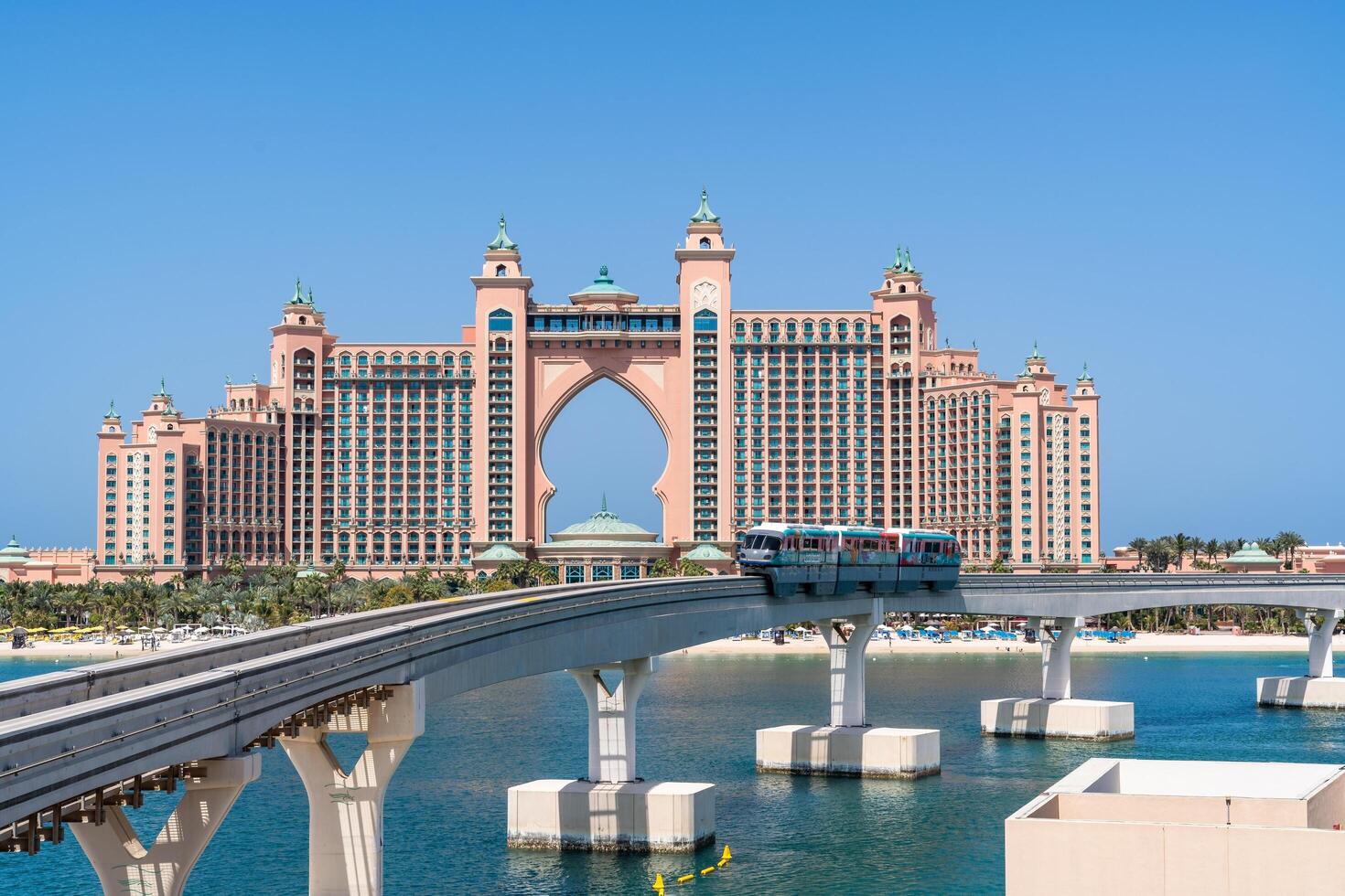 Dubai, United Arab Emirates - March 17, 2023-Monorail at Palm Jumeirah with the famous Atlantis Hotel in the background during a sunny day photo