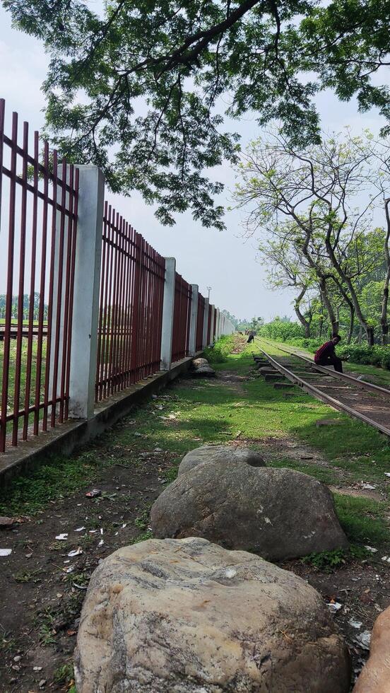 a fence with a large rock in the middle of it photo