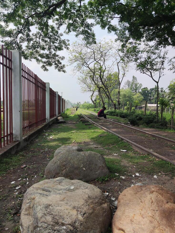 Scenic view of railroad tracks with boulders and trees photo