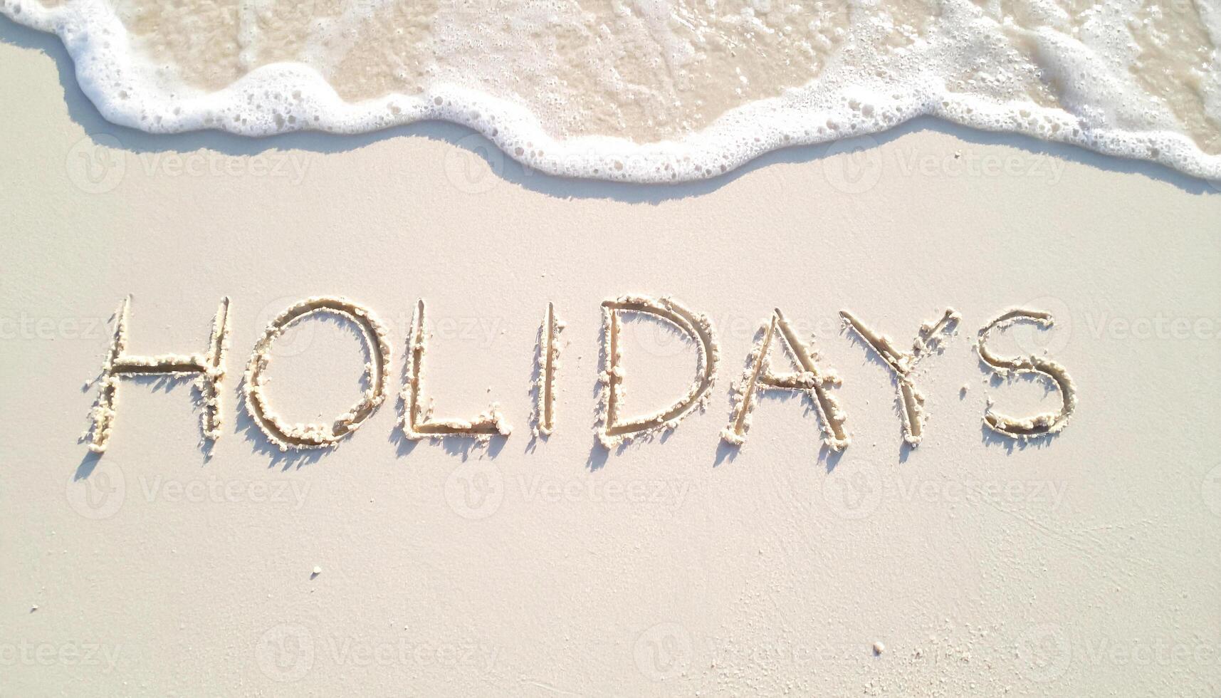 summer background with finger written text holiday on sand and sunny beach vibe photo