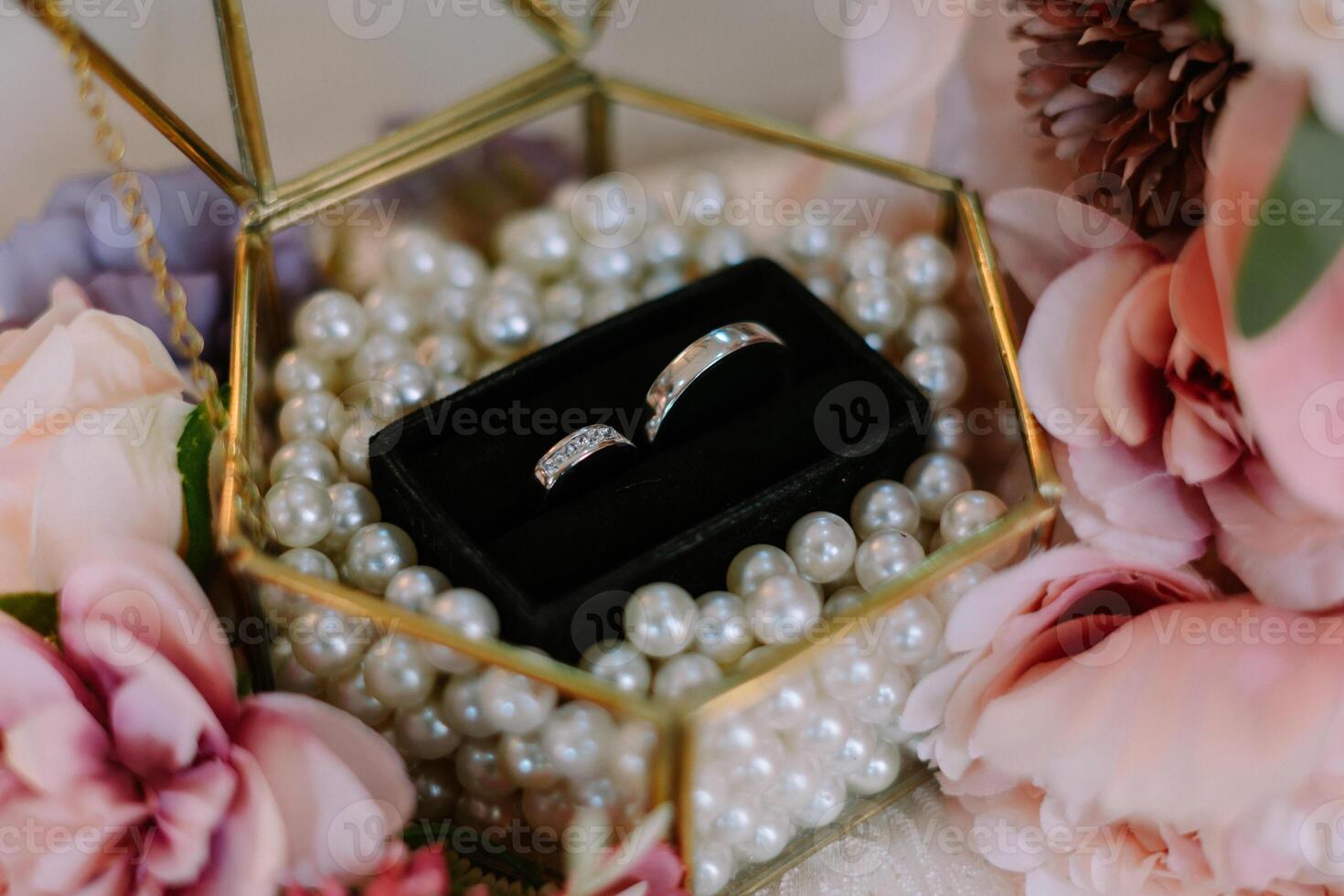 Elegant Wedding Rings Displayed with Pearls and Soft Floral Accents photo