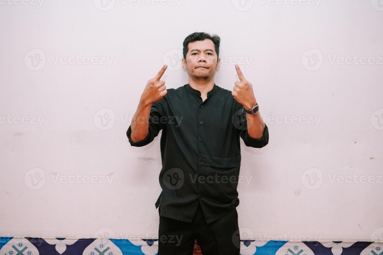 Man pointing upwards in dark shirt providing visual direction photo