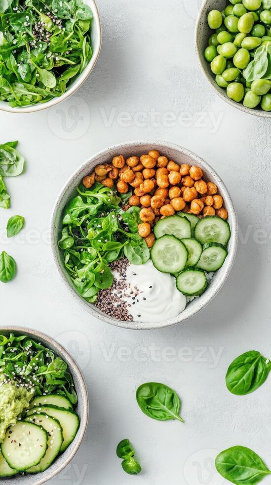 Overhead view of bowls filled with fresh vegetables, beans, chickpeas, and seeds on a light gray background. Healthy, natural and nutritious food photo