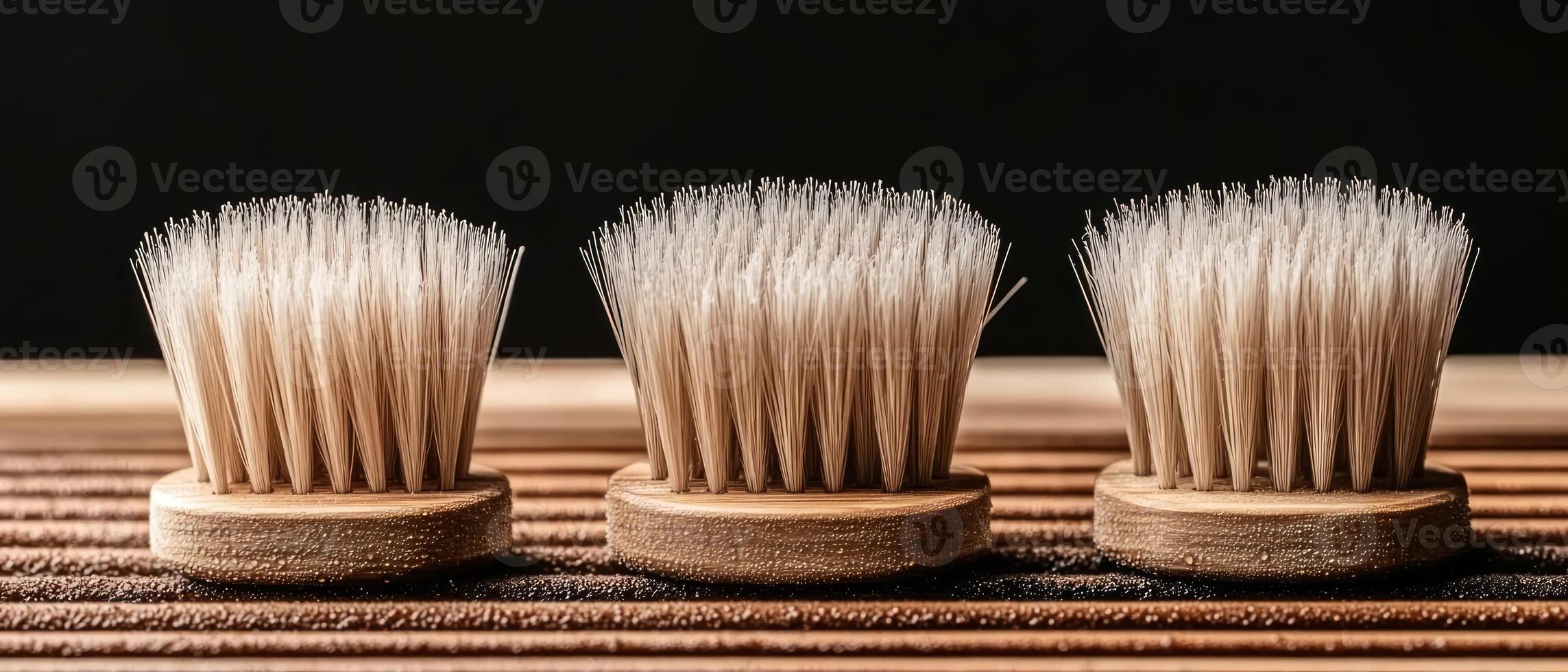 Three wooden brushes with different bristle types lie on a wooden surface, showcasing their design and versatility for various cleaning tasks photo