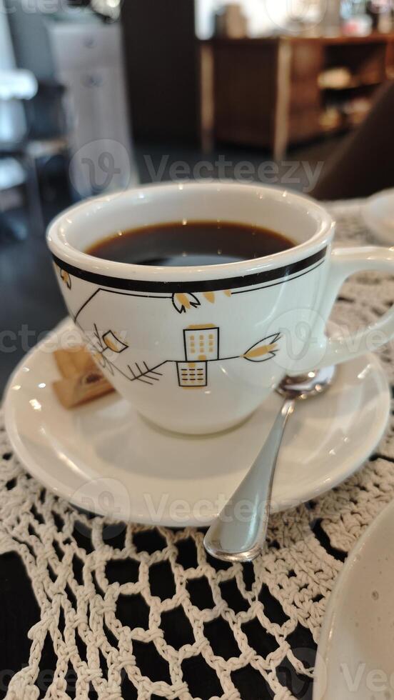 Cup of black coffee served on a saucer photo