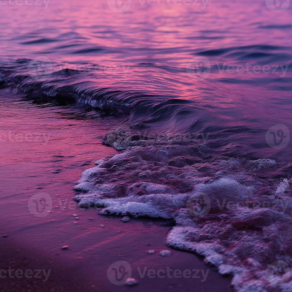 Waves gently lapping against the shore at sunset photo
