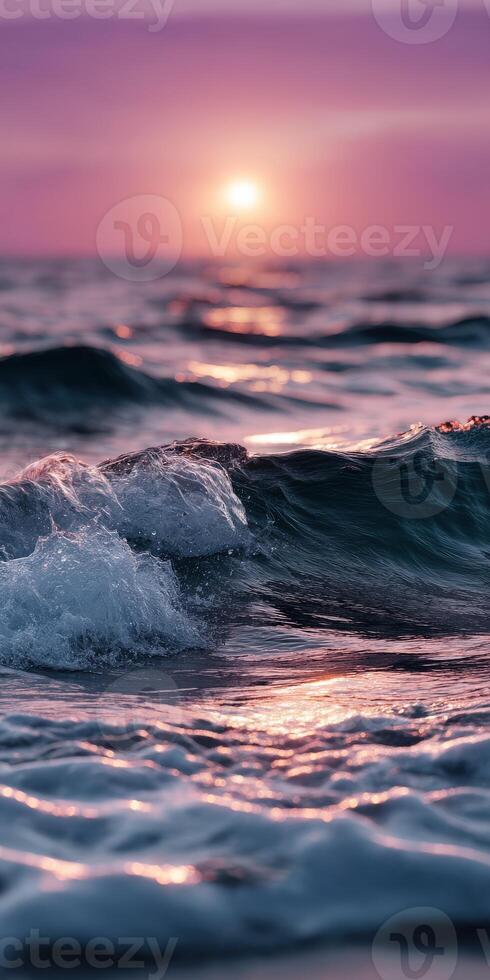 Sunset over waves creating ripples at the ocean shore photo