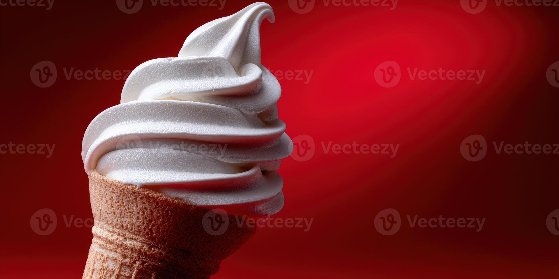 Delicious soft serve ice cream in a cone against red background photo