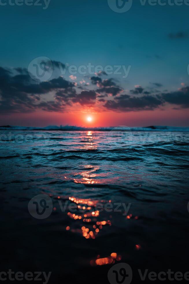 Beautiful sunset over the ocean reflecting on calm waters photo