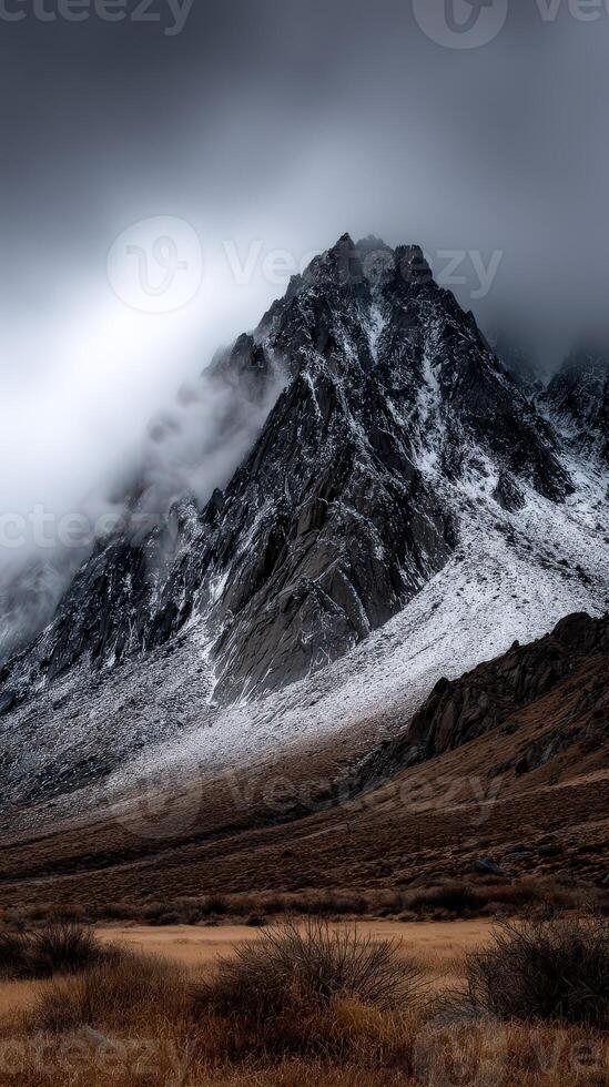 Snow-covered mountain peak under a cloudy sky in twilight photo