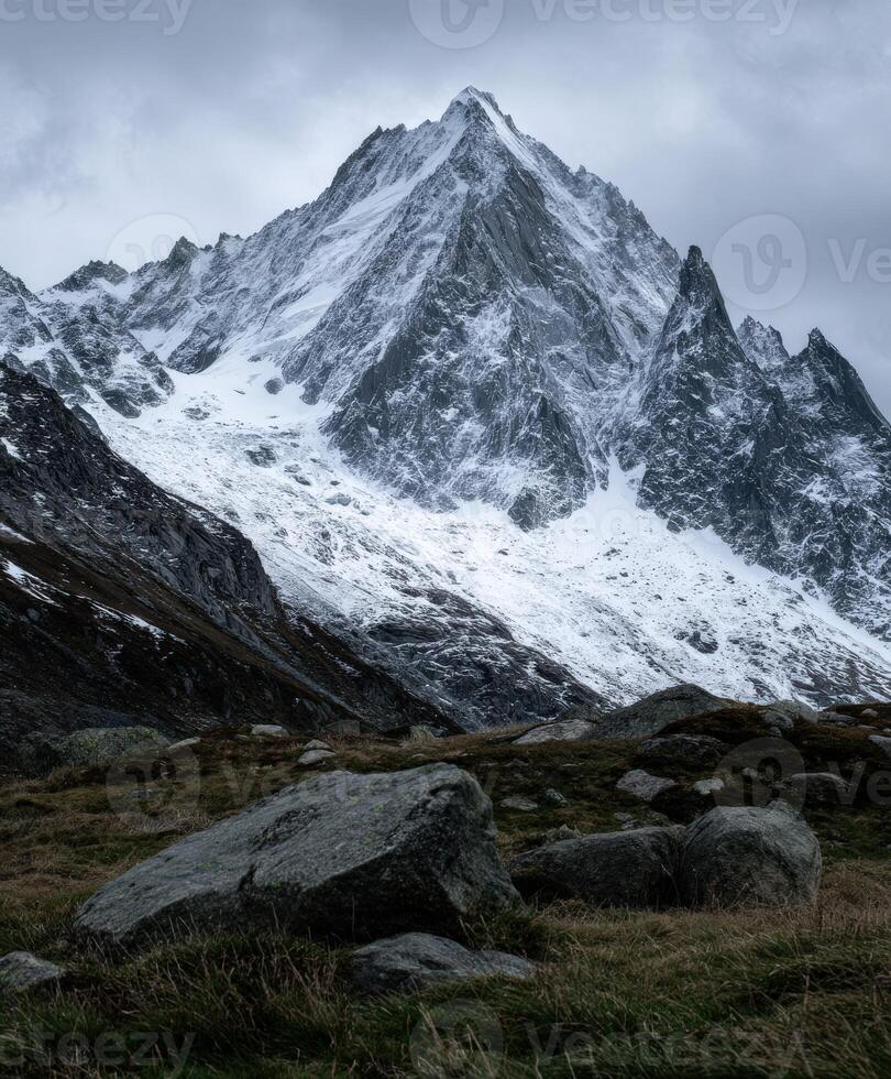 Snow-capped mountain peak under cloudy sky in winter season photo