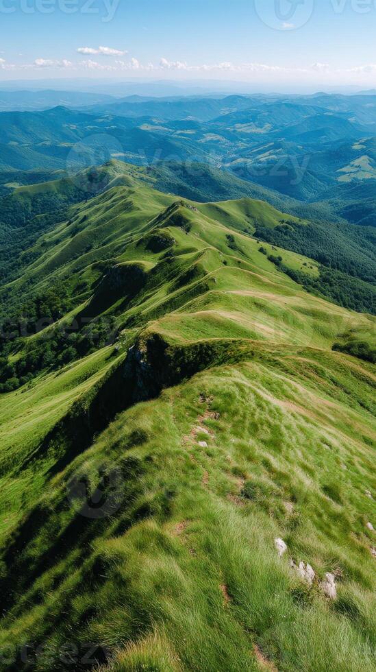 Vibrant green hills under clear blue sky in summer photo